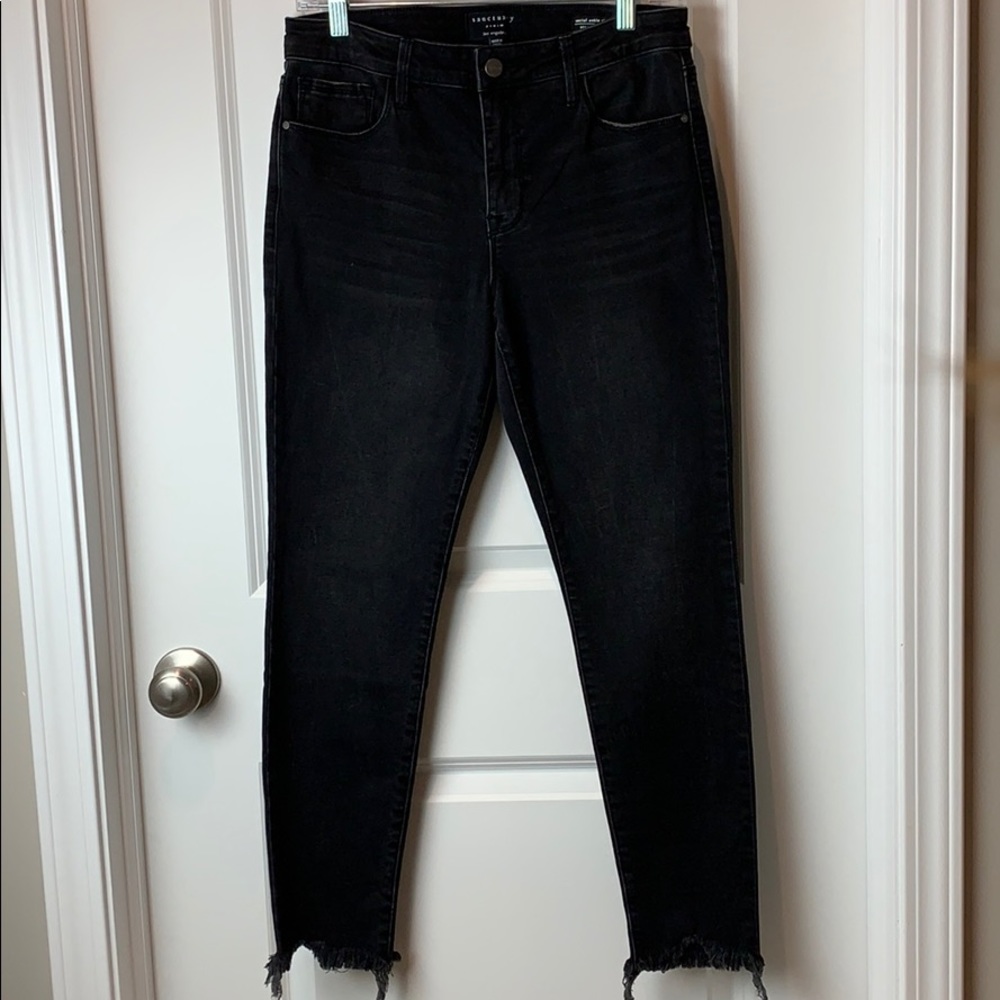 Black skinny jeans with frayed hem.